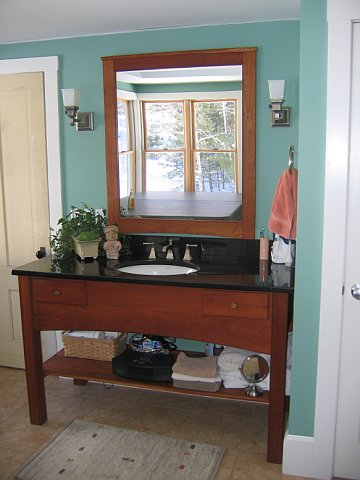 Contemporary cherry vanity, and mirror with hand tool detailing.