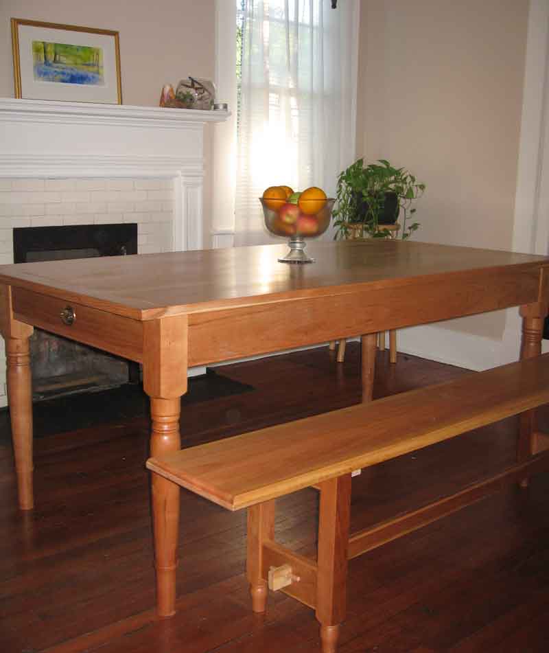 Handmade, bespoke contemporary cherry table with breadboard ends in a Shaker design featuring two hand dovetailed end drawers and hand turned legs with a natural finsih. Also shown is a cherry handmade bench to complement the order. Sent to Savanna, Georgia. This cherry hardwood table could be made to any size, in any wood and customer preferences.
